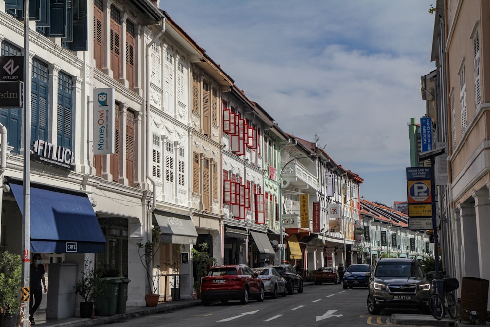 Autos, die tagsüber vor einem weißen und braunen Betongebäude geparkt sind