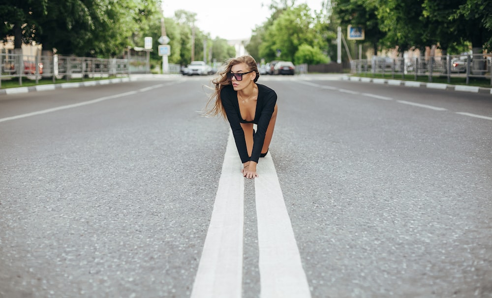 woman in brown blazer standing on road during daytime