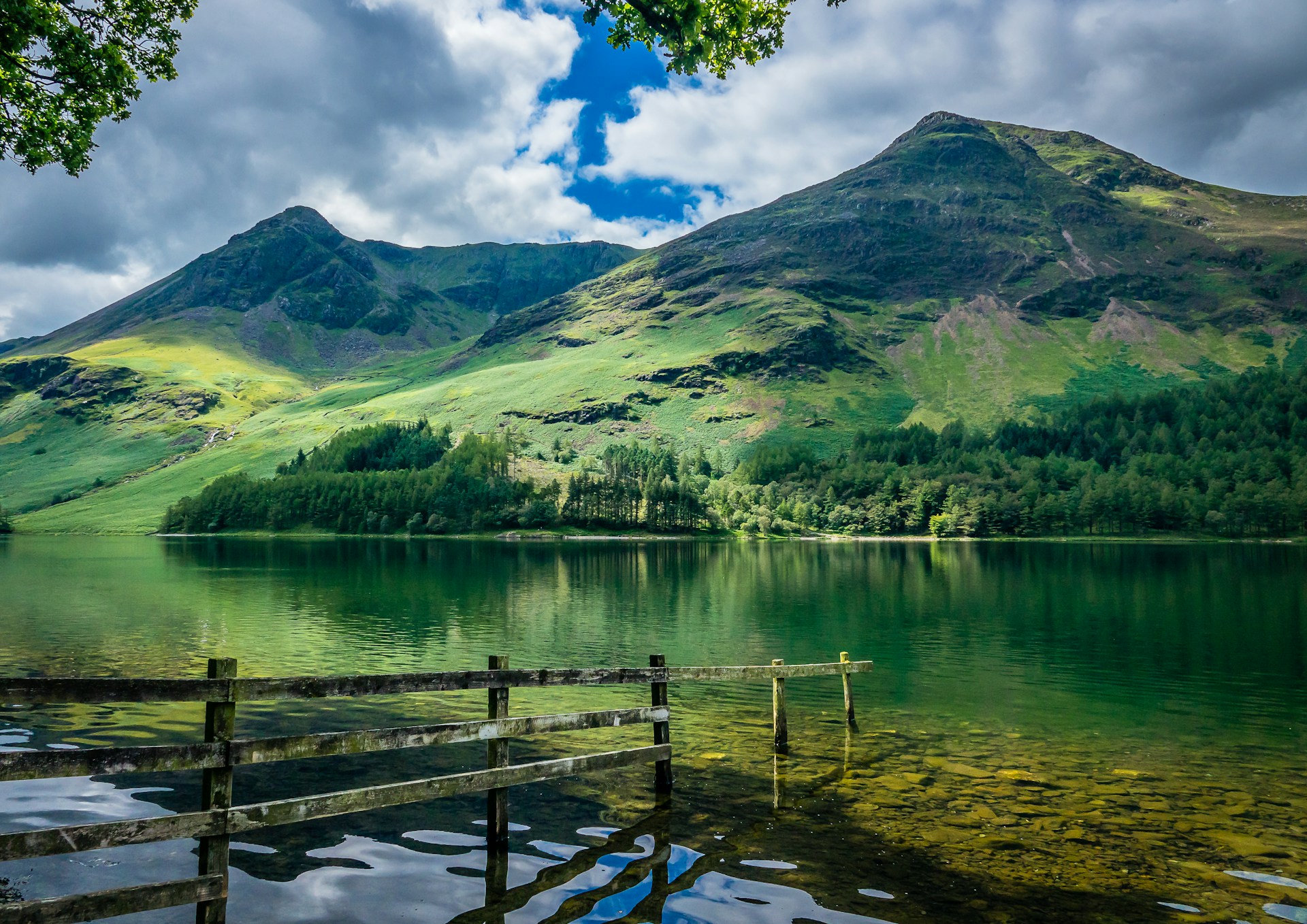 green and brown mountains beside body of water during daytime