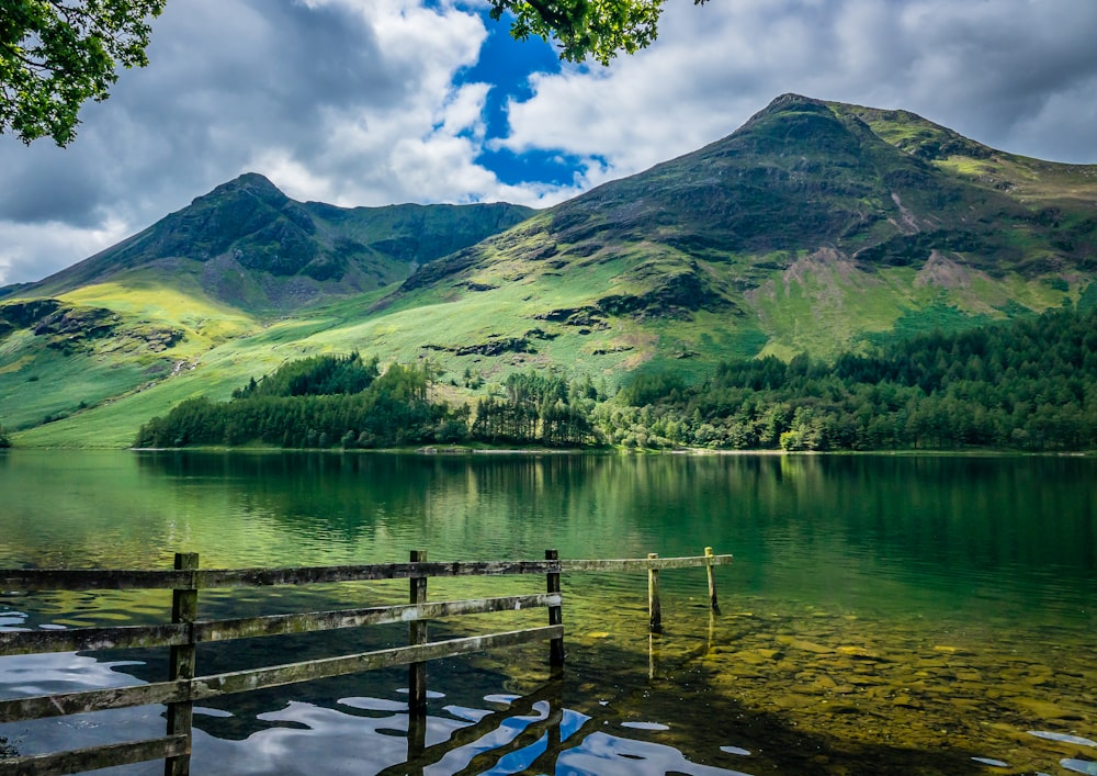 green and brown mountains beside body of water during daytime