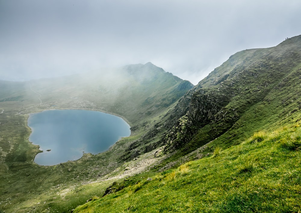 Montagna verde vicino al lago durante il giorno