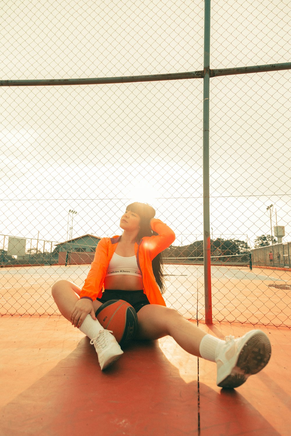 woman in red sports bra and white shorts sitting on basketball court