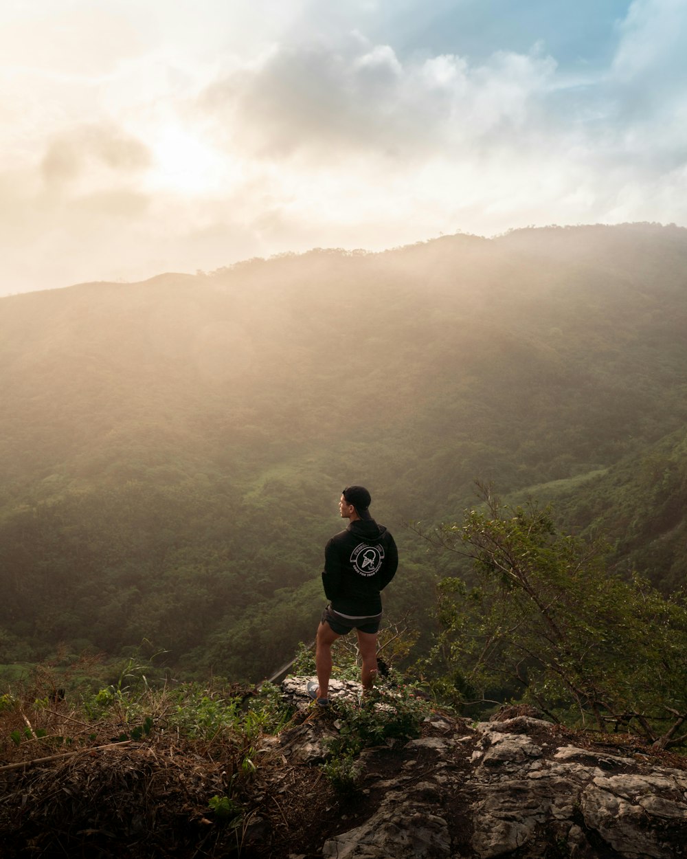 man in black t-shirt standing on brown rock mountain during daytime