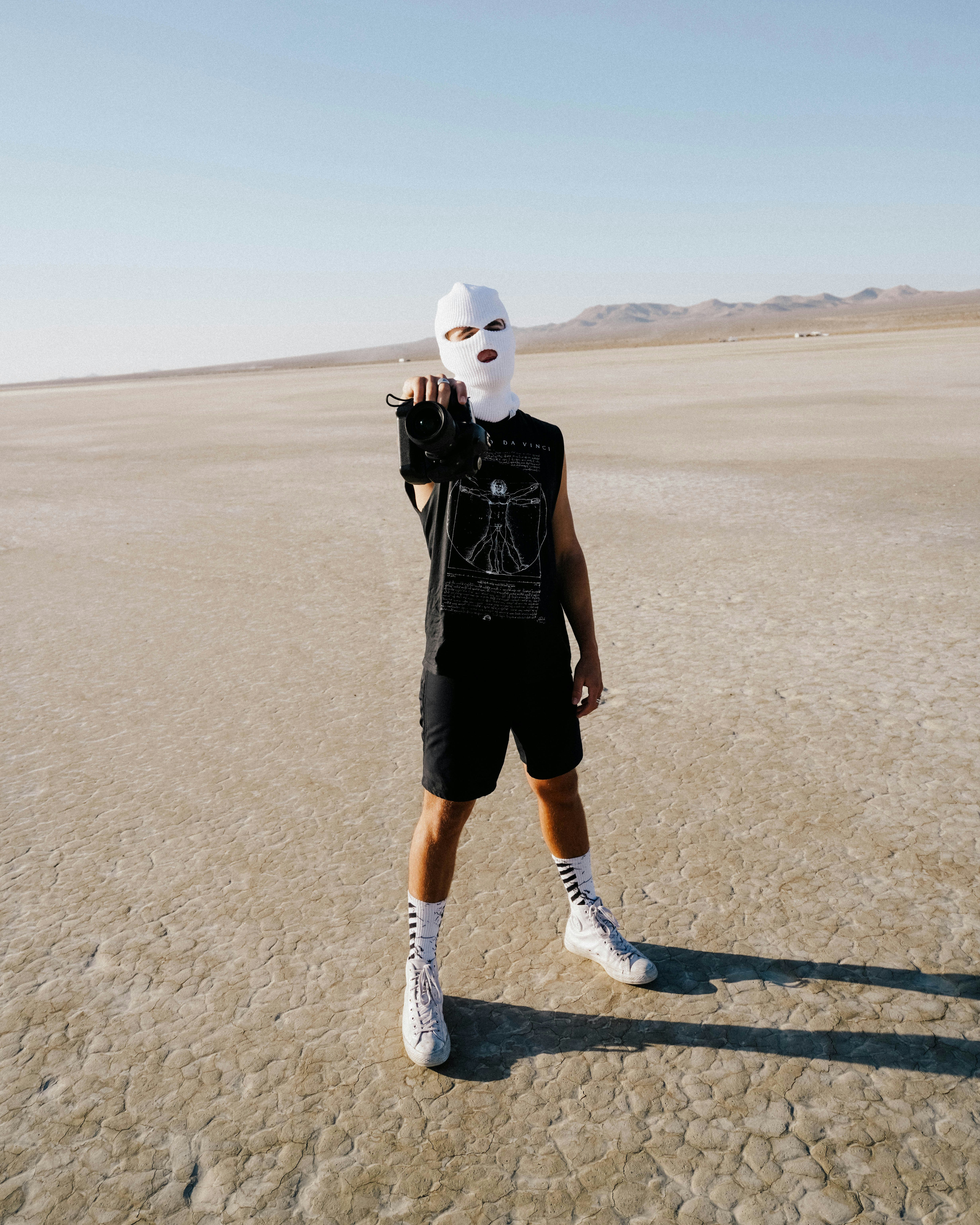 man in black t-shirt and black shorts wearing white nike sneakers