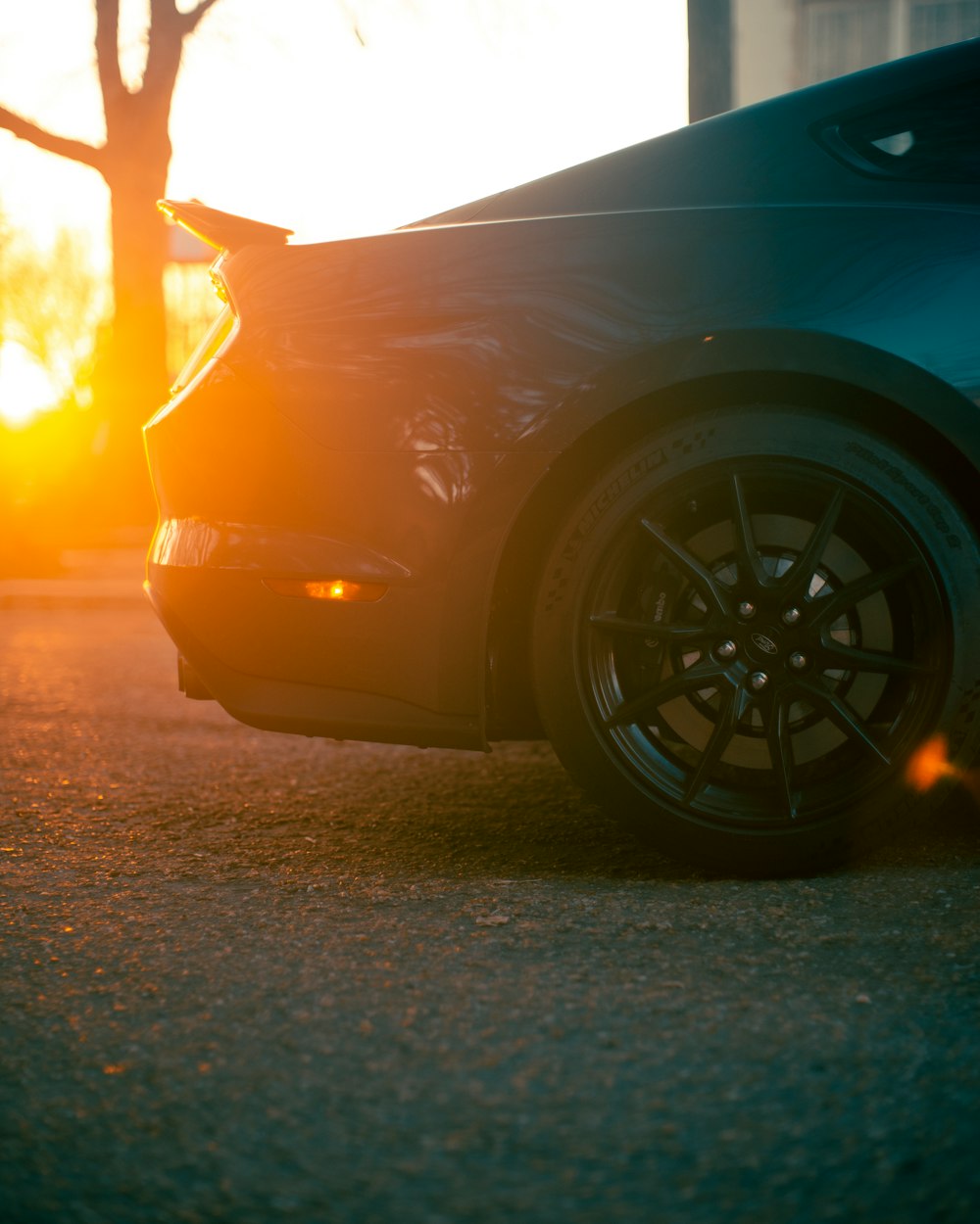 blue car on gray asphalt road during sunset