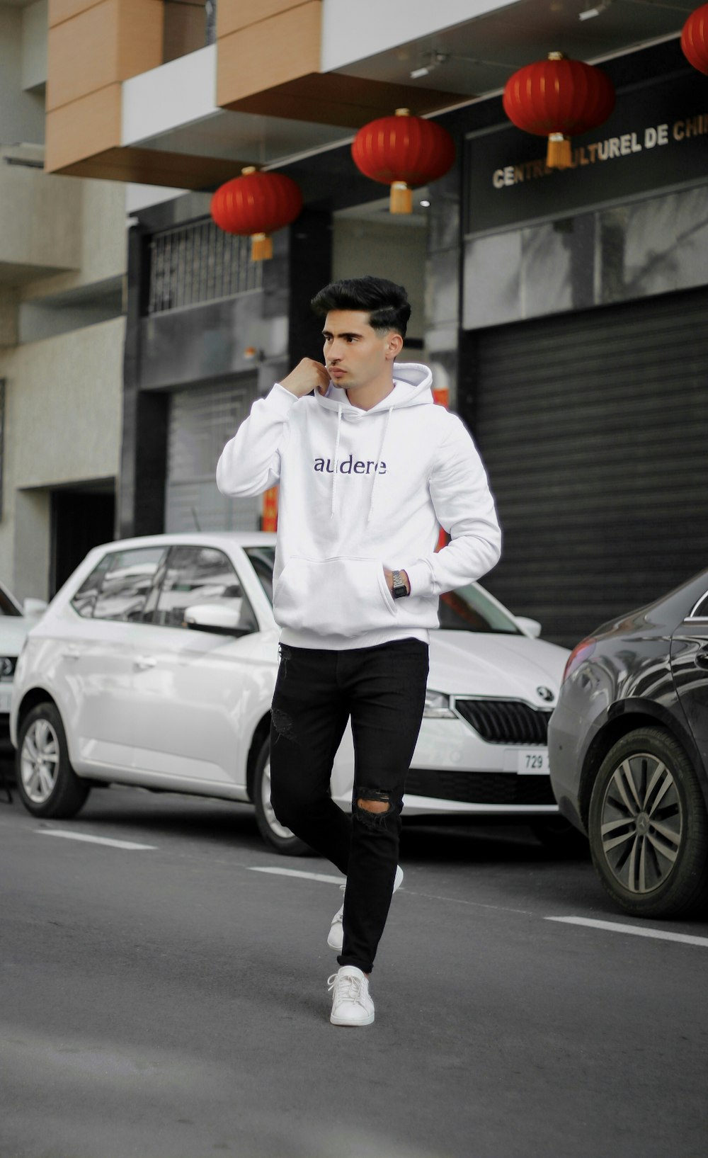 man in white jacket and black pants standing beside white mercedes benz coupe during daytime