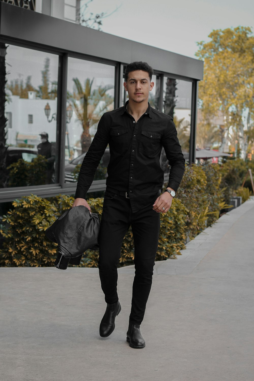 man in black coat holding black umbrella