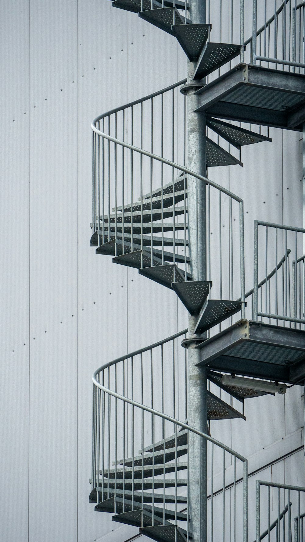 Escalera de caracol blanca con pared blanca