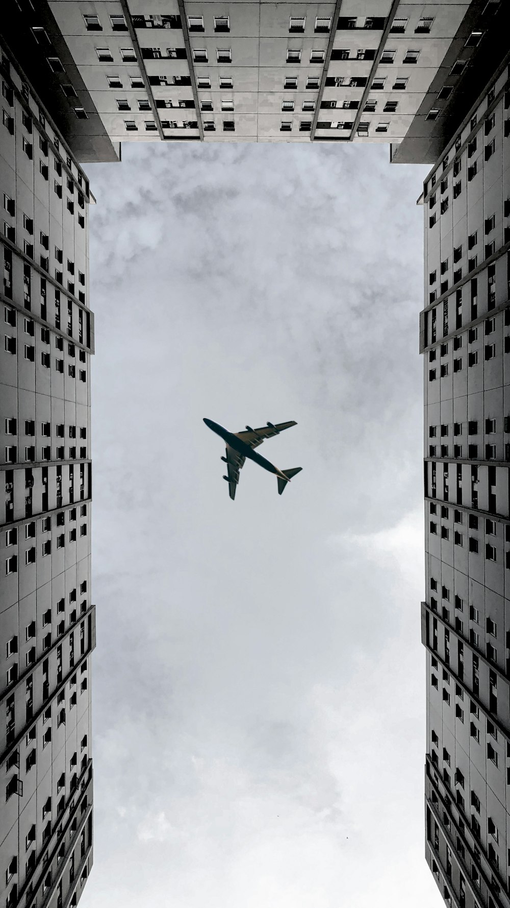 airplane flying over the building during daytime