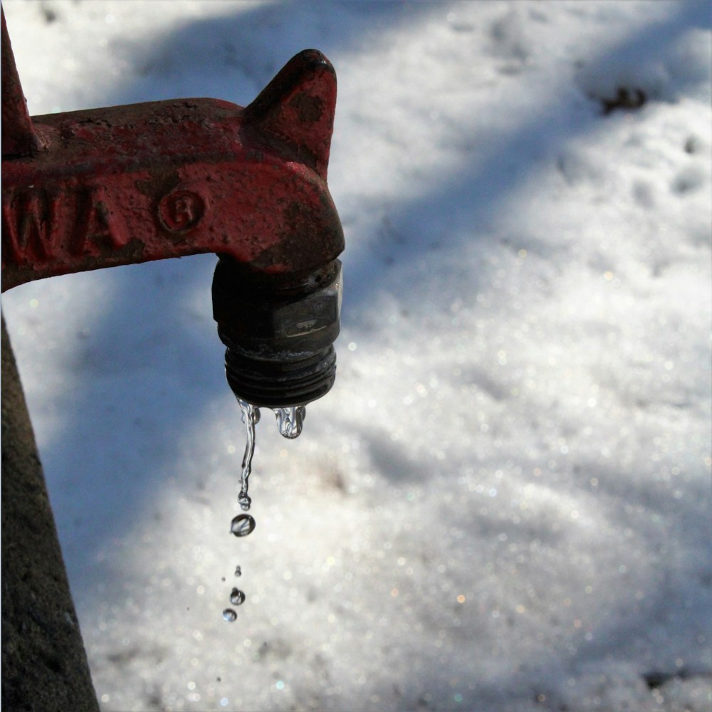 Herramienta de metal rojo en suelo cubierto de nieve