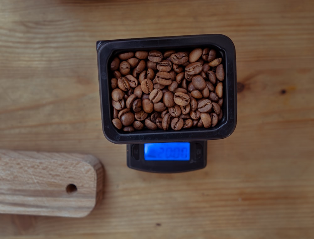 brown almond nuts in black plastic container