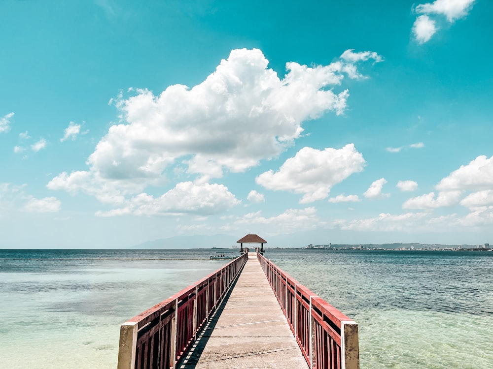 brown wooden dock on sea under blue sky during daytime