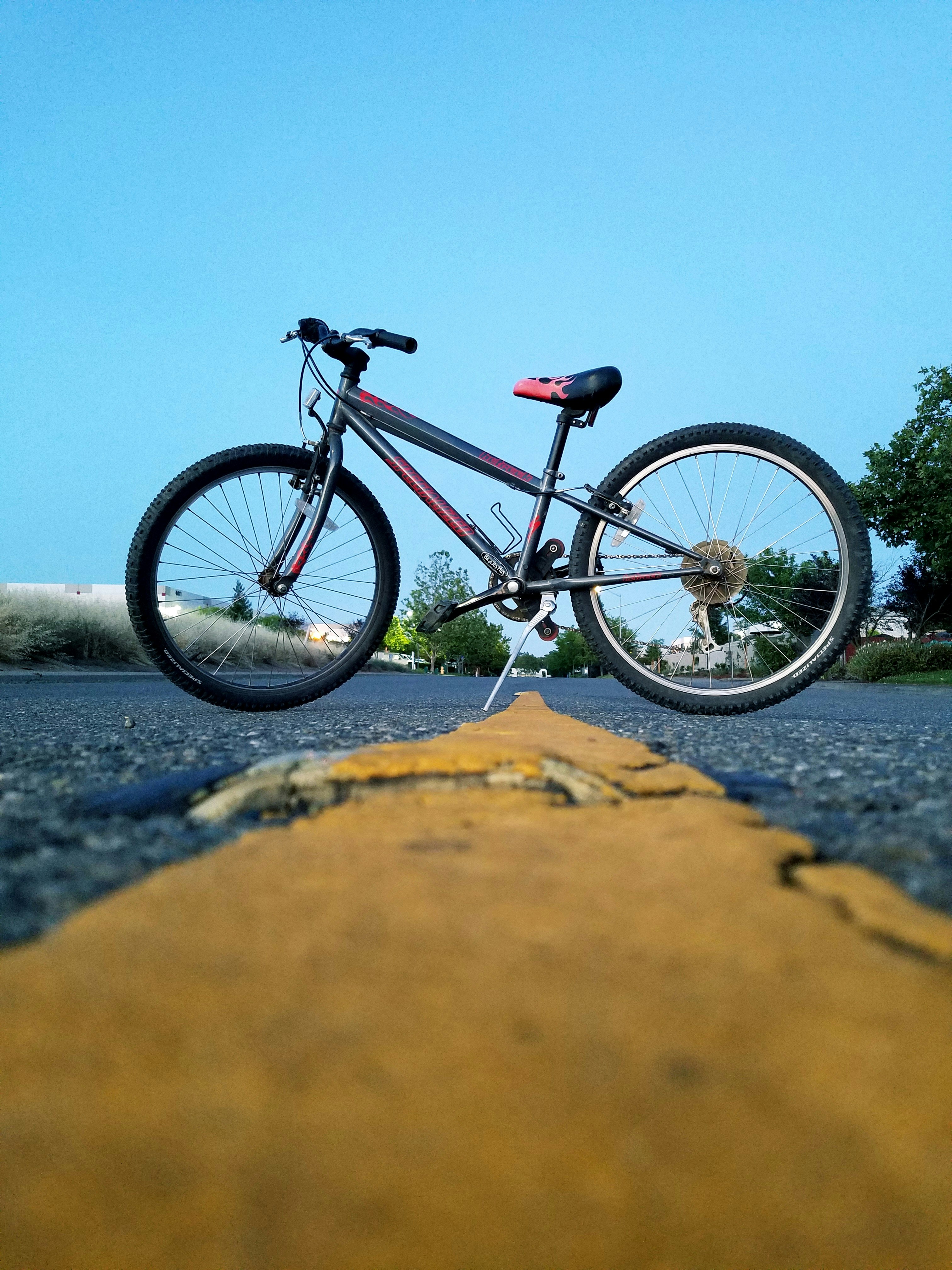 black and red mountain bike on brown sand during daytime