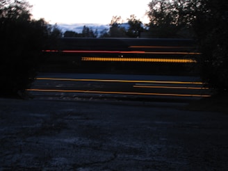 Nighttime shot of Raj Express bus illuminated on a highway.
