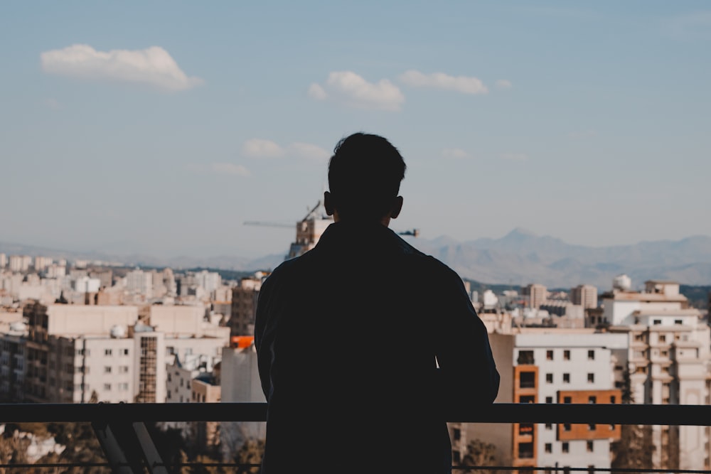 man in black jacket standing on top of building during daytime