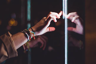 person wearing silver bracelet holding a light