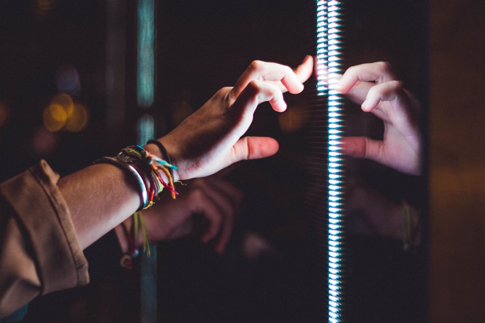 person wearing silver bracelet holding a light