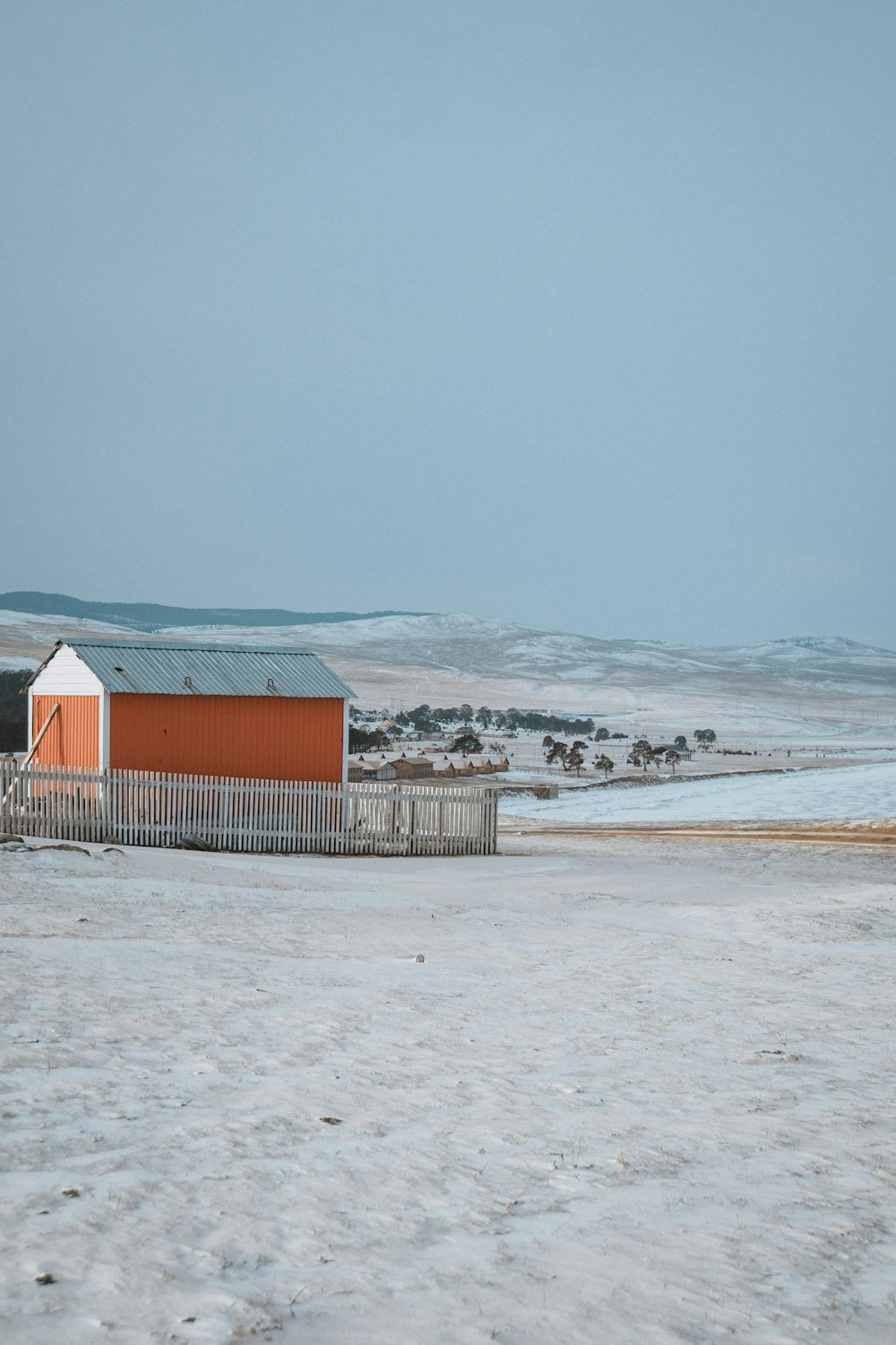 red and white wooden house on snow covered ground during daytime