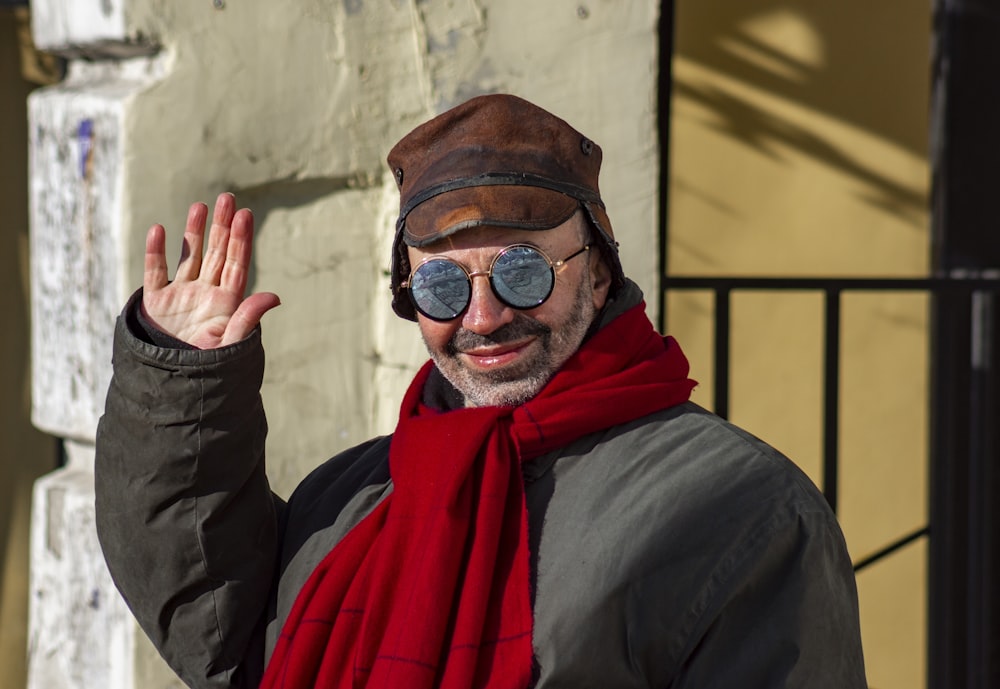 man in black jacket wearing red scarf and black sunglasses