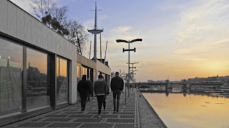 A team strolling along Lisbon's riverfront under a sky painted with soft autumn gold tones.