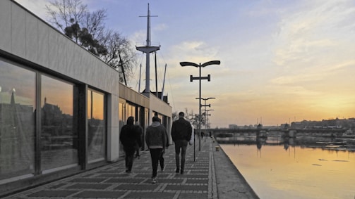 A team strolling along Lisbon's riverfront under a sky painted with soft autumn gold tones.