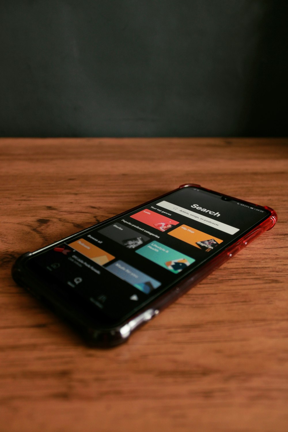 Schwarzes iPhone 4 auf braunem Holztisch