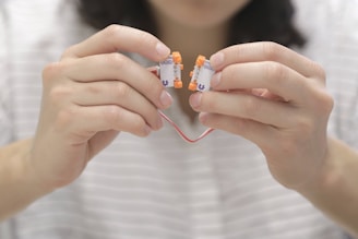 Hands fitting a new electronic component inside a household appliance.