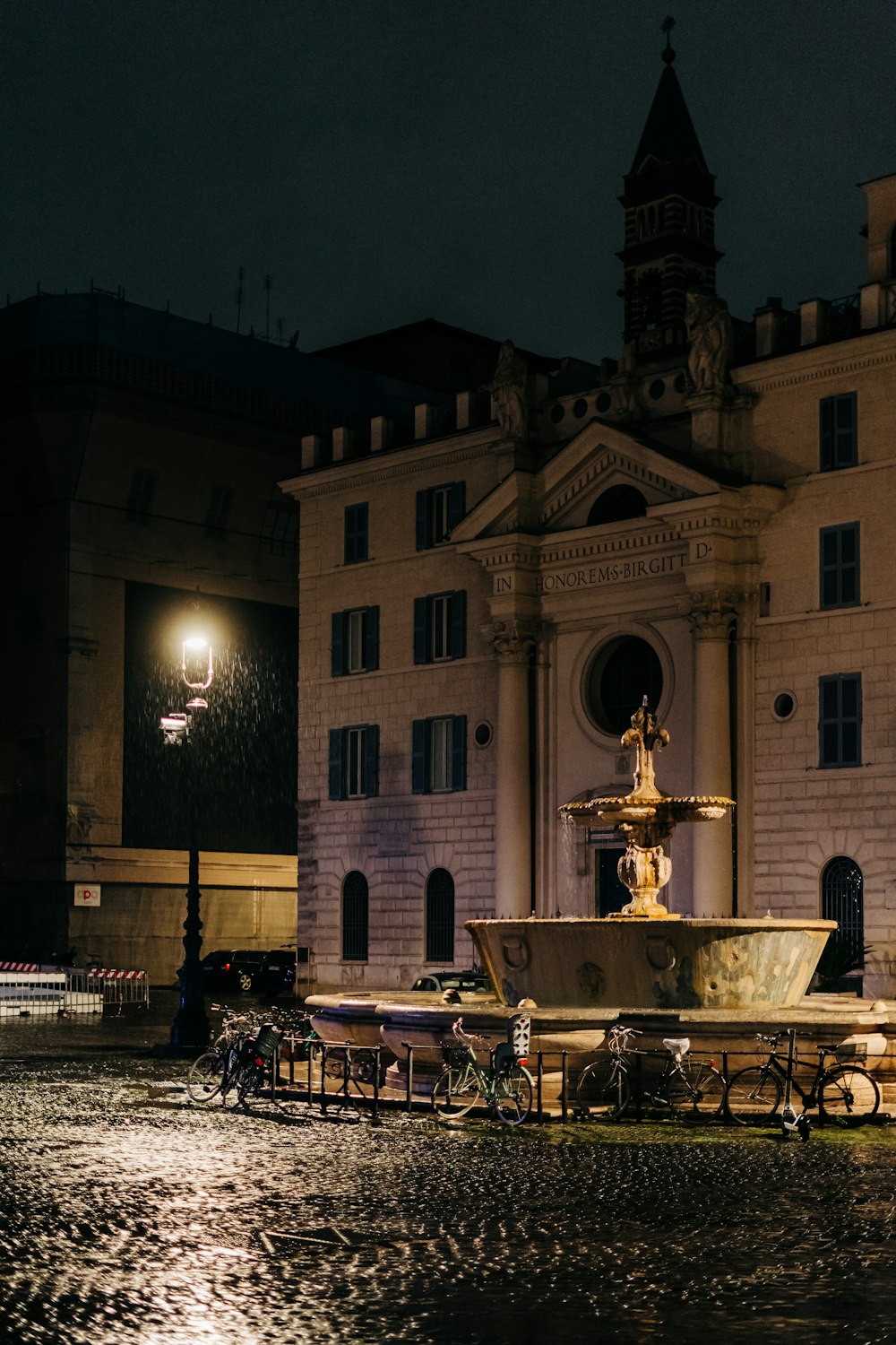 Weißes Betongebäude mit Springbrunnen während der Nacht