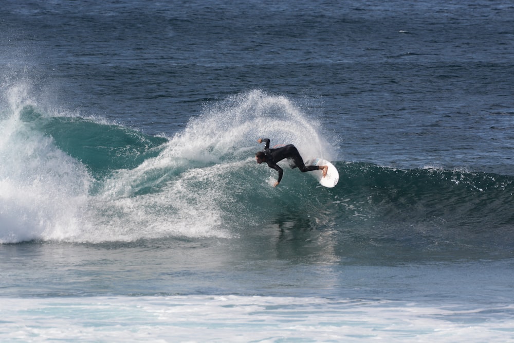 man surfing on sea waves during daytime