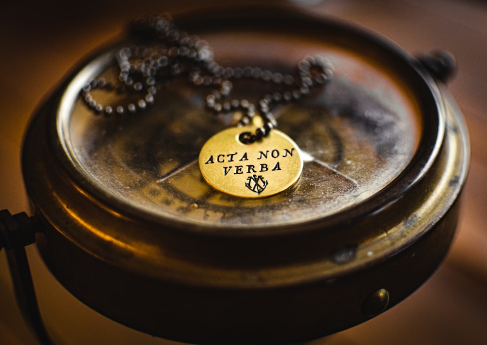 silver round pendant necklace on brown round container