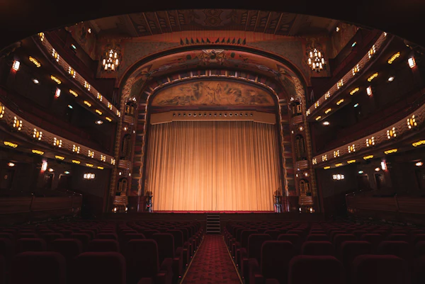 Theater with red seats and gold curtain