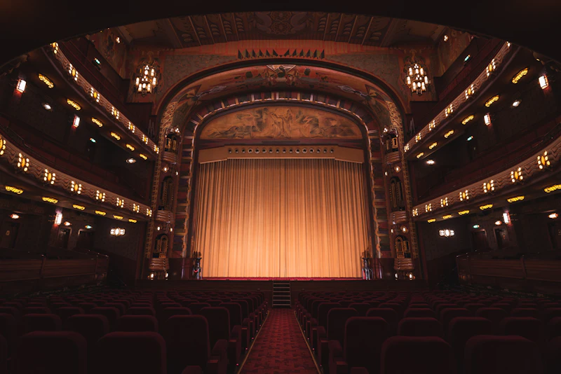 Theater with red seats and gold curtain