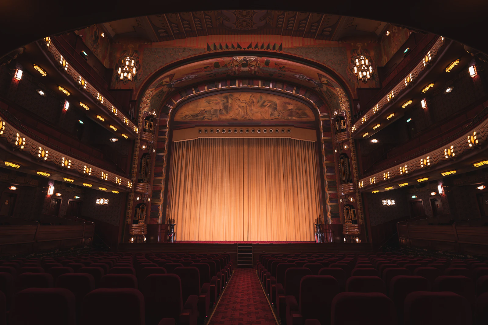 Interior de teatro com poltronas e cortina fechada — foto ilustrativa