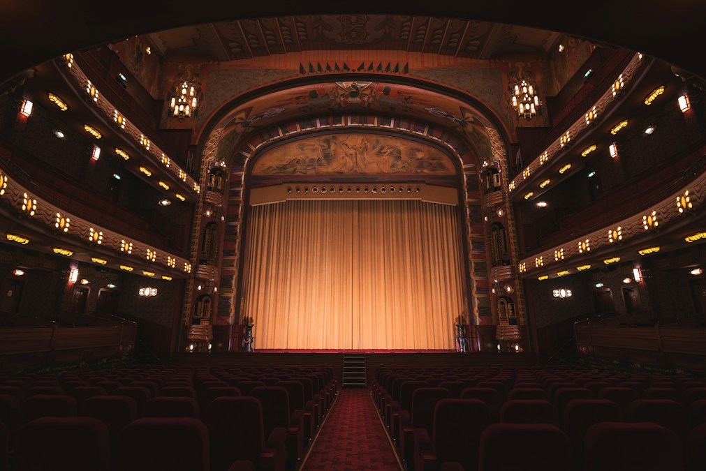 Empty theatre with elegant red seats and stage lighting