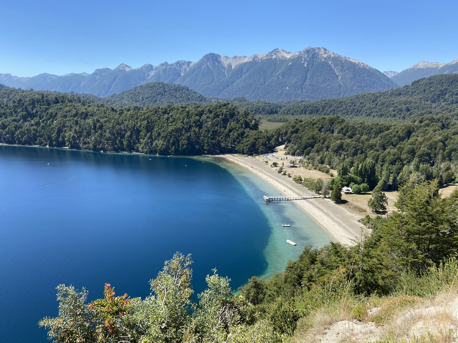 Blue water and forested mountains at Lago Espejo in Neuquén