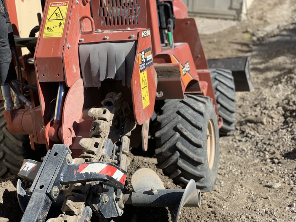 red and black tractor on brown soil