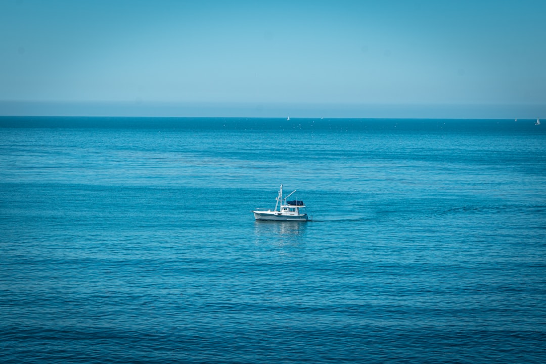 white boat on blue sea under blue sky during daytime