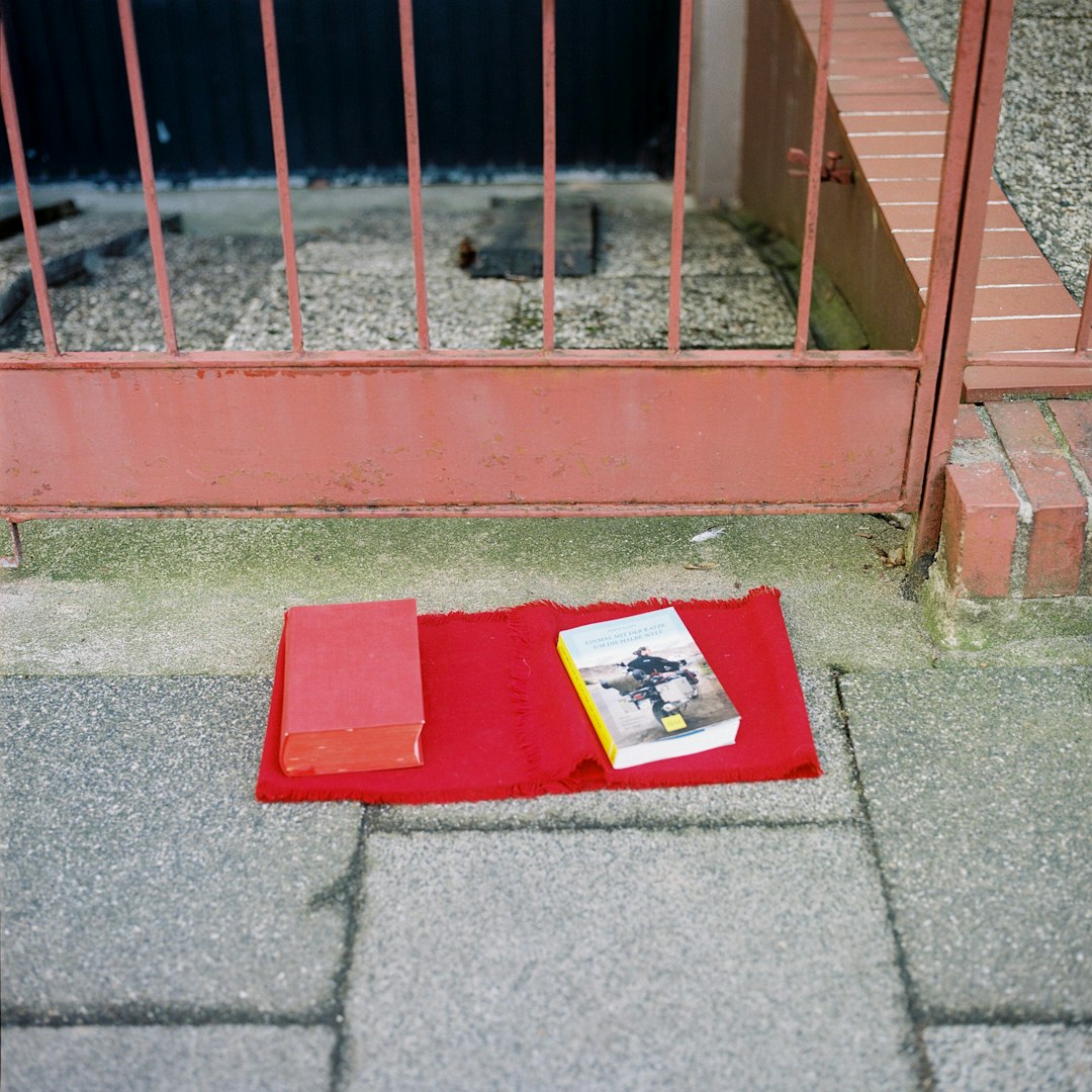red and white book on gray concrete floor