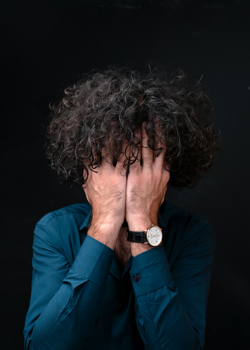 woman in blue long sleeve shirt covering her face with her hair