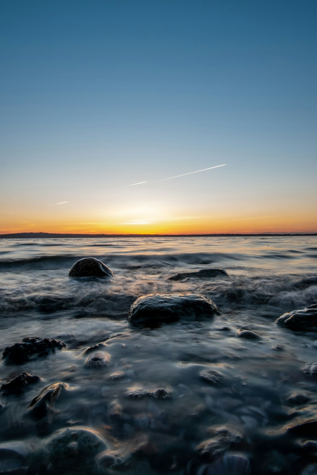 ocean waves crashing on rocks during sunset