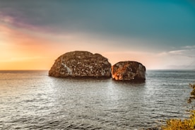 brown rock formation on sea during daytime
