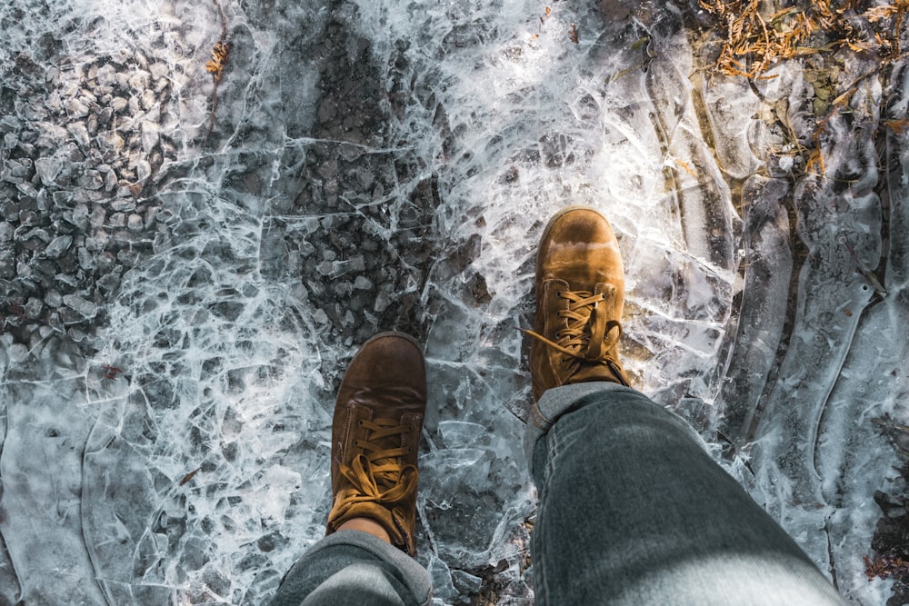 person in blue denim jeans and brown leather shoes