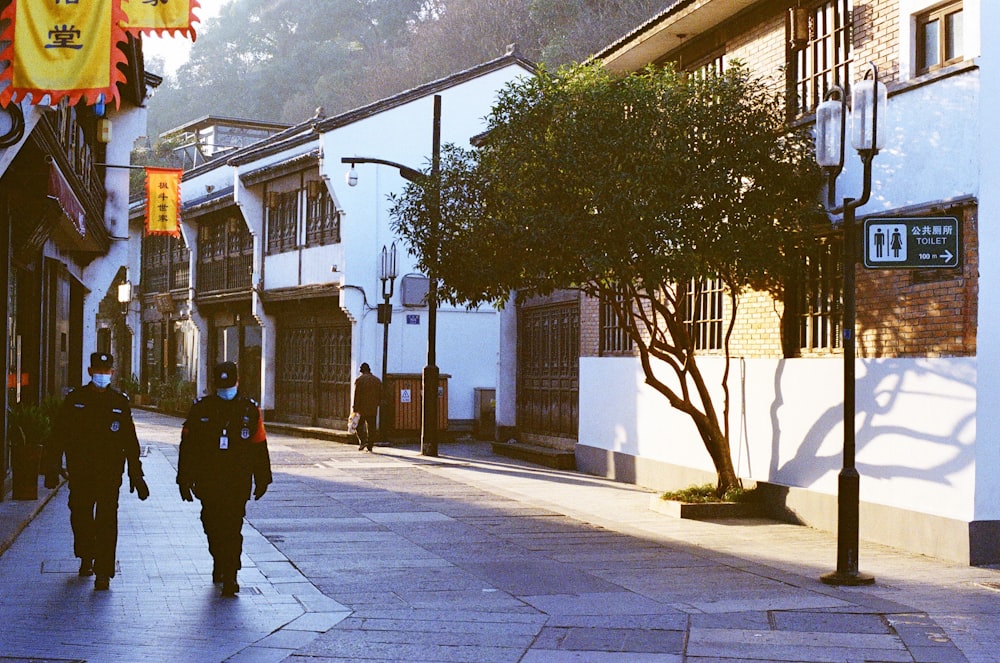 man in black jacket walking on sidewalk during daytime