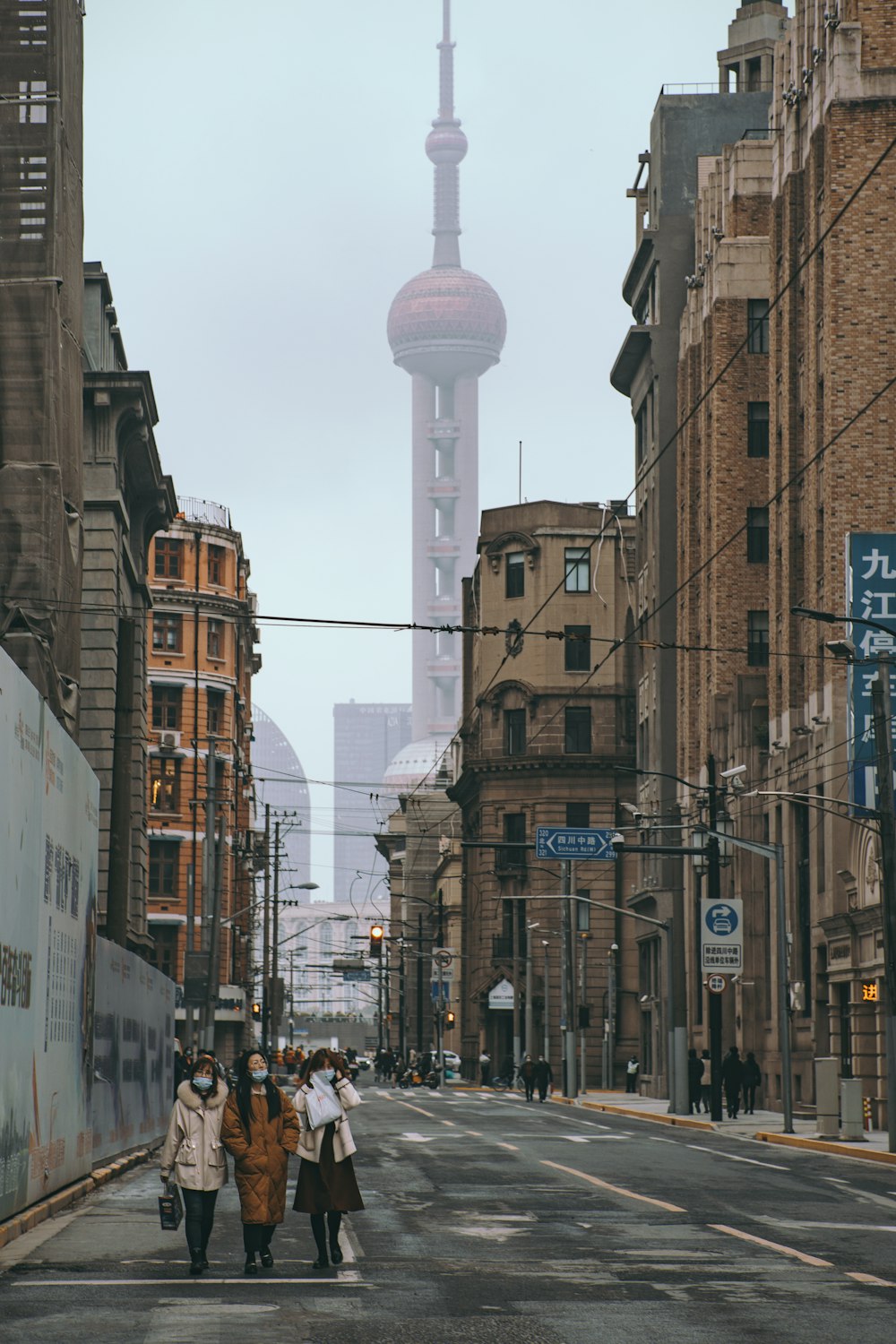 people walking on street between high rise buildings during daytime