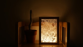 A resin inlay map of San Diego, glowing softly with embedded LED lights, displayed on a rustic wooden frame.