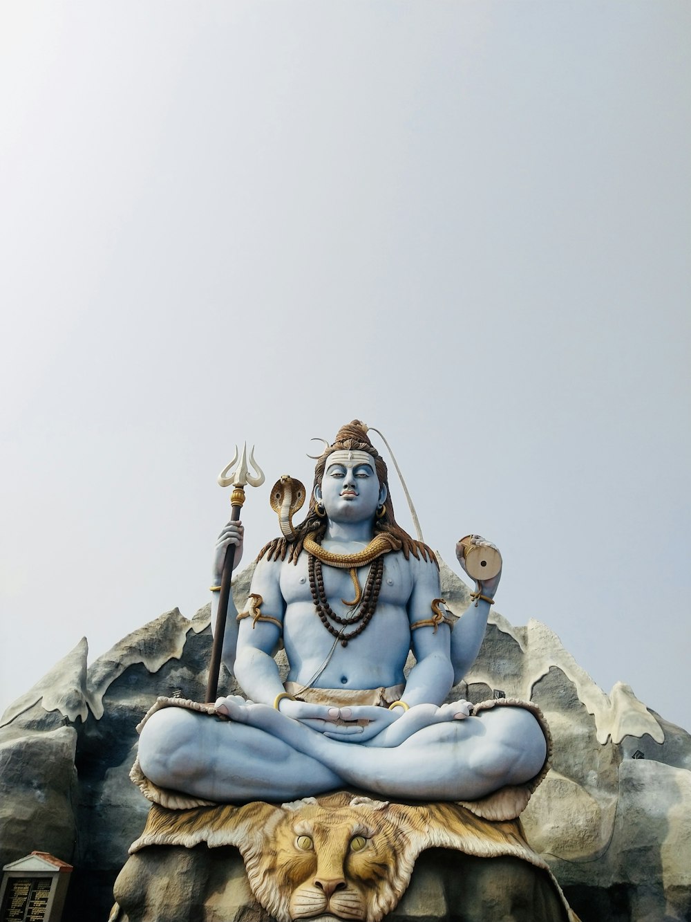 woman in blue dress sitting on rock