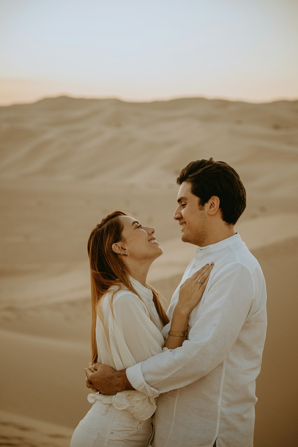 man and woman in white long sleeve shirt kissing