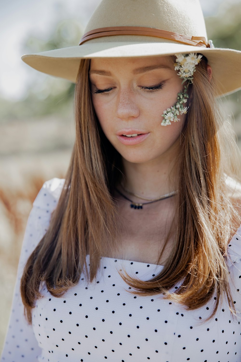 woman in white and black polka dot shirt wearing white floral headband