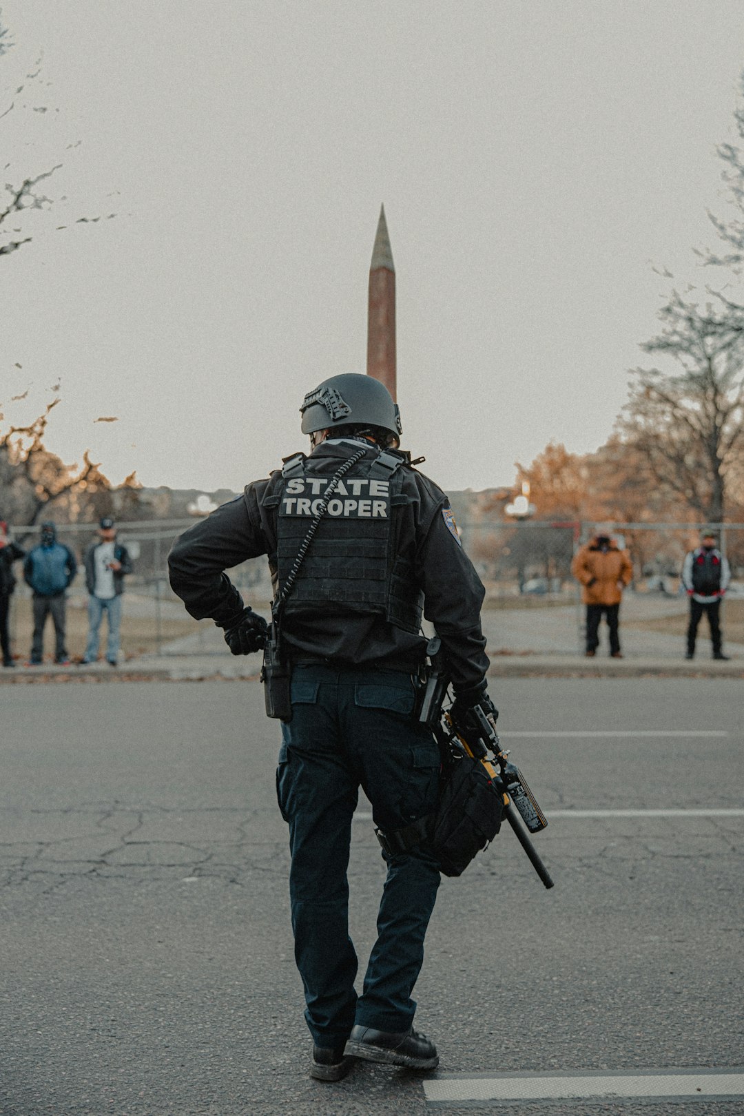 man in black jacket and pants holding black rifle
