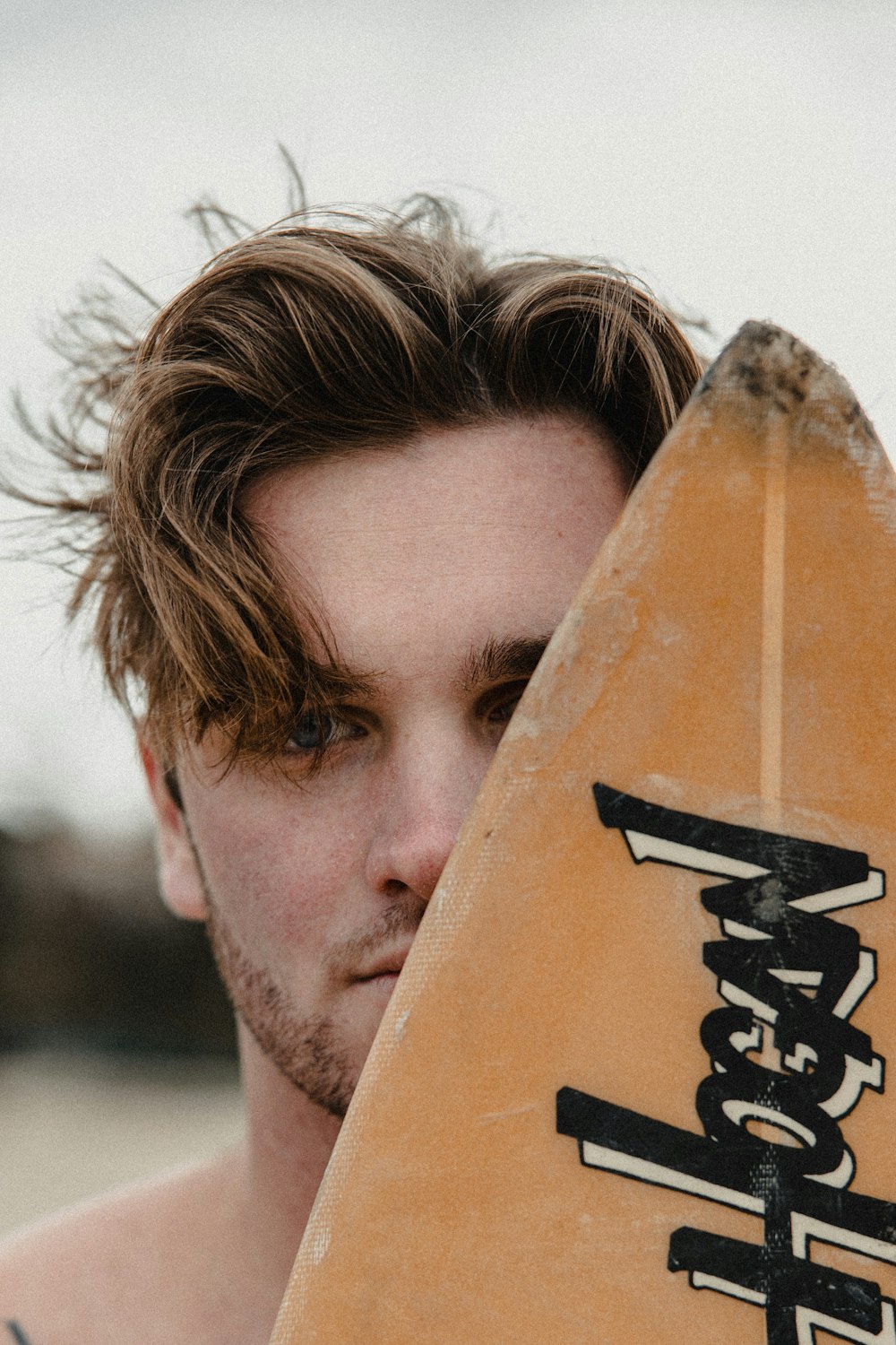 man holding brown wooden board